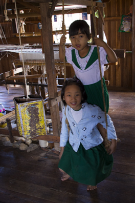 Children playing amongst the weaving looms in  Inphaw Khone Village on Lake Inle